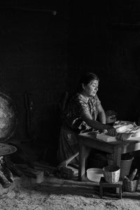 Black and White Photograph of woman cooking in Zincatan, Mexico.